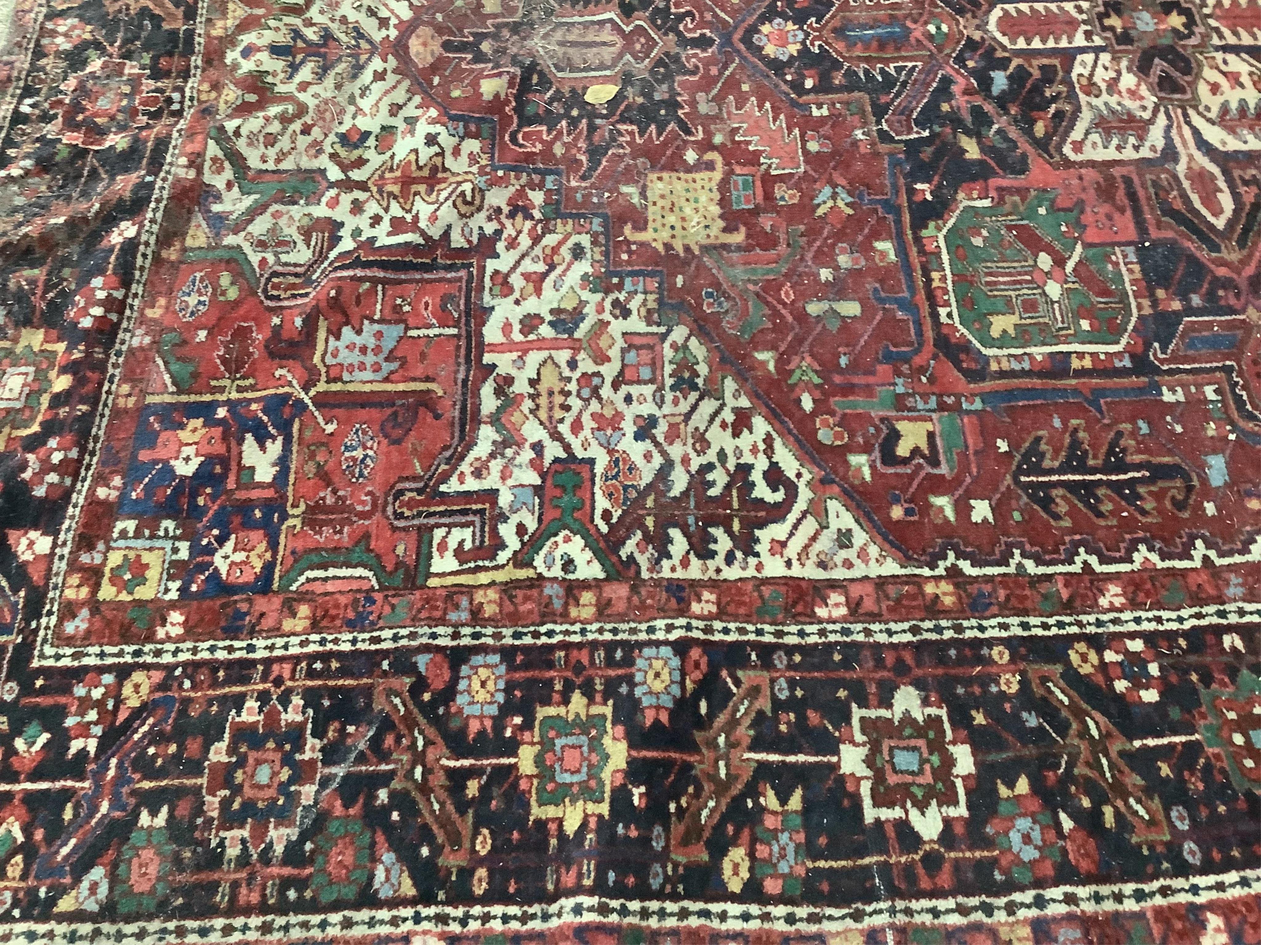 A Heriz red ground carpet, 340 x 267cm. Condition - poor to fair